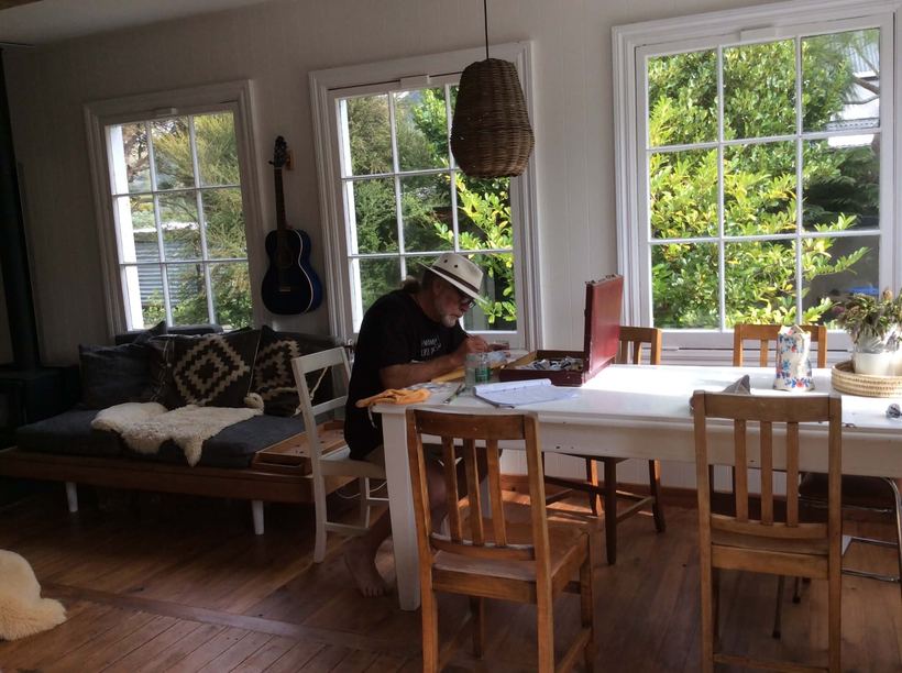 At the table, working on something small
